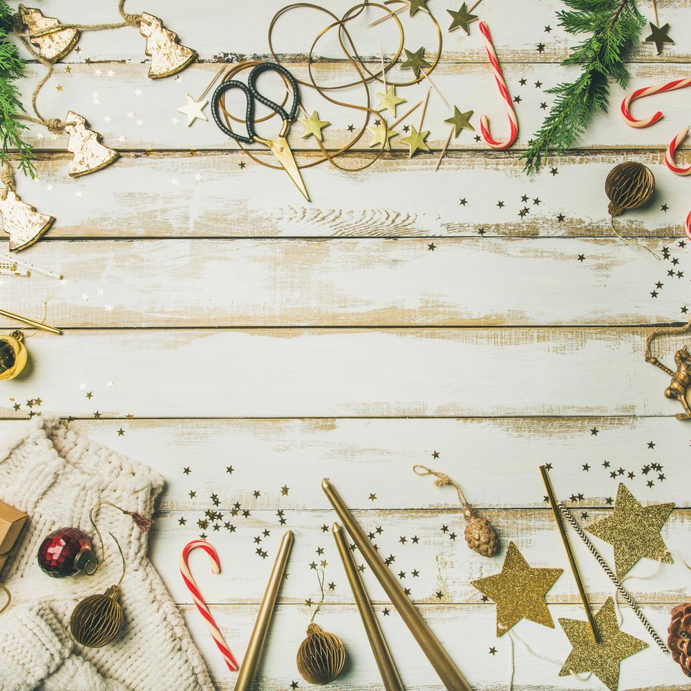 Decorations of stars, candy canes, scissors, candles on light background, square crop, copy space