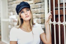 Wistful woman holding onto window railing