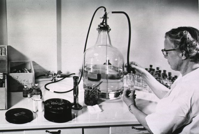 Female scientist working in laboratory with large beaker