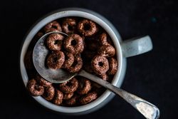 Traditional breakfast with chocolate cereal in mug with spoon