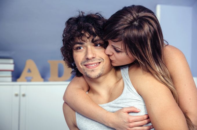 Beautiful woman kissing and embracing smiling man