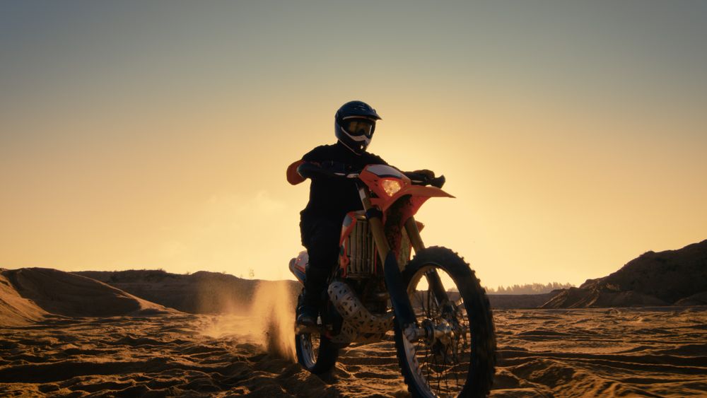 Low Angle Shot of the Professional Motocross Motorcycle Rider Standing on the Path of the Off-Road Track.