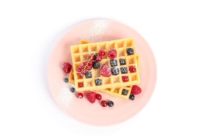 Belgian waffles with berries on plate isolated on blank background