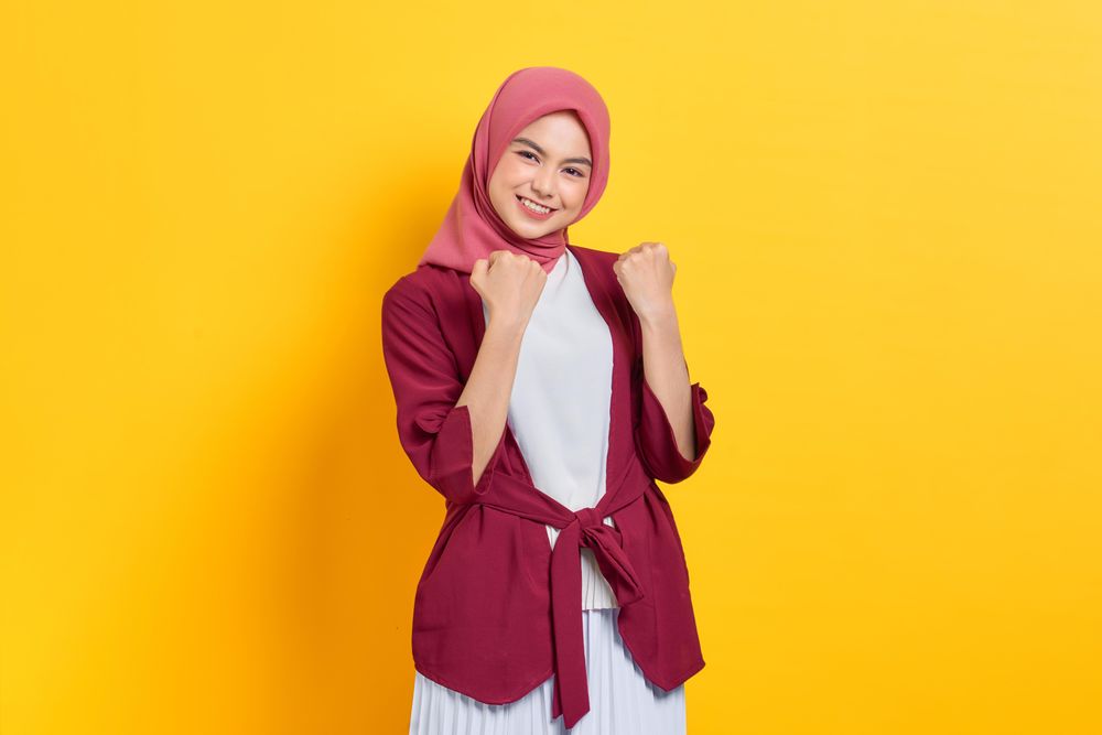 Woman in red headscarf playfully making two fists