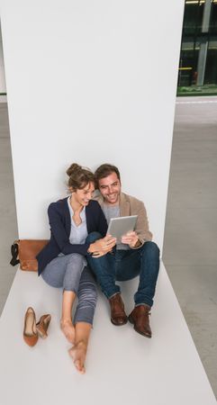 Businesspeople hugging and using tablet on street