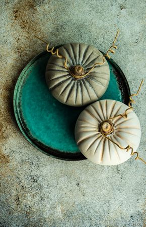 Top view of ceramic pumpkins decorating teal tableware