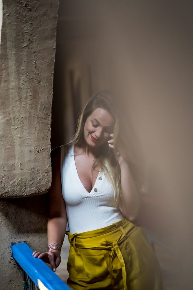 Smiling woman using smartphone on old balcony
