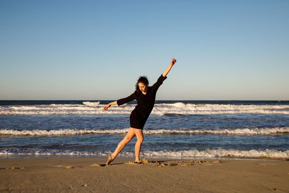 Woman with dancing near water on shore