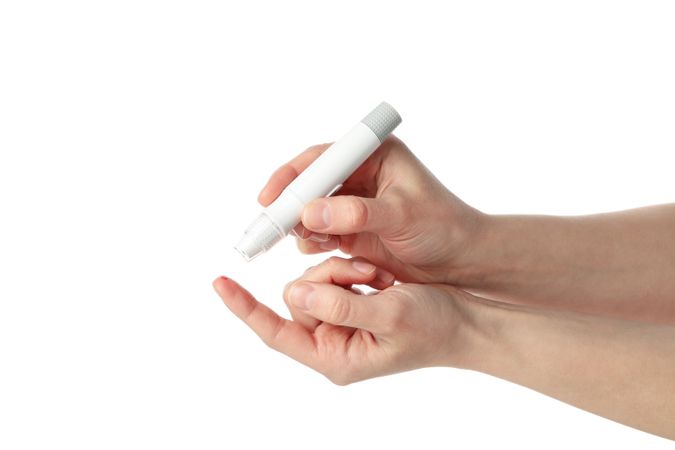 Female checking blood sugar level, isolated on light background