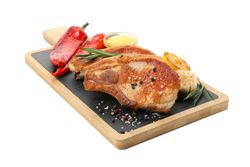 Board with fried steaks and vegetables isolated on blank background