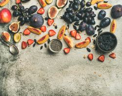 Fruit assortment with figs, grapes, peaches, spoon, chia seeds,  horizontal composition, copy space