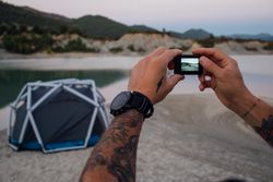 Screen of man’s camera taking picture of tent