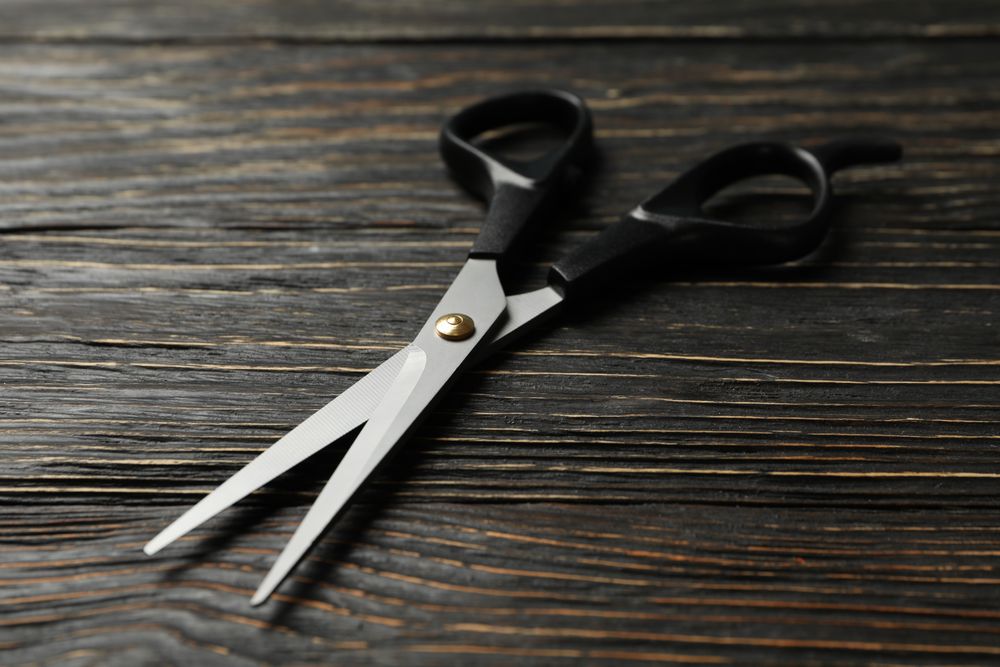 hairdresser scissors on wooden background, close up