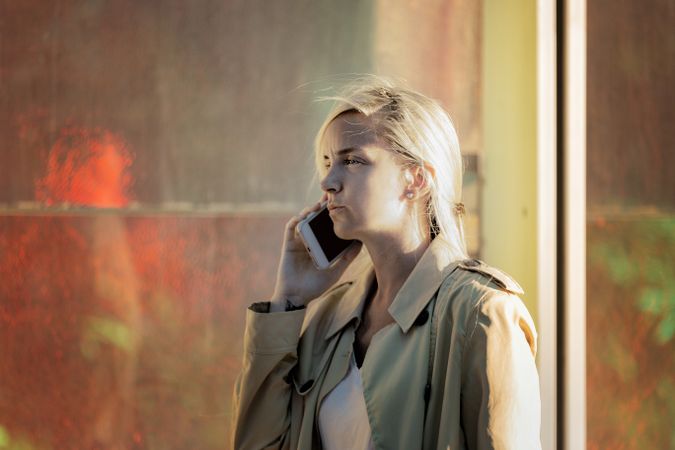 Traveling woman speaking on the phone near an airport