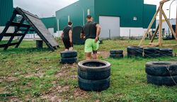 Participants in an obstacle course dragging wheels