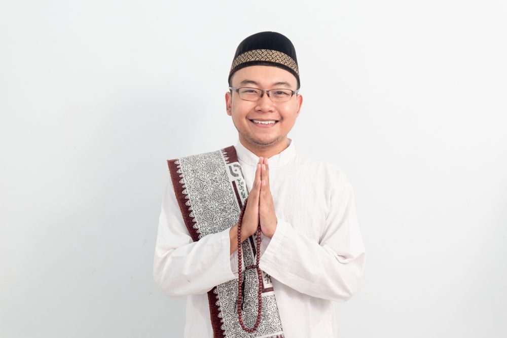 Asian Muslim man smiling doing greeting pose during Ramadan