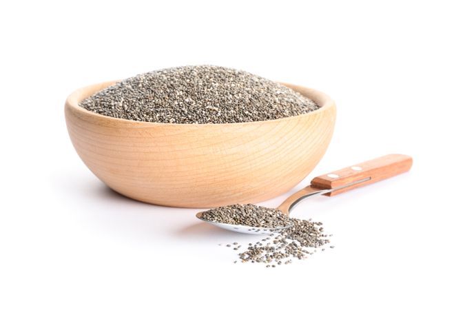 Chia seeds in wooden bowl and spoon isolated on neutral background