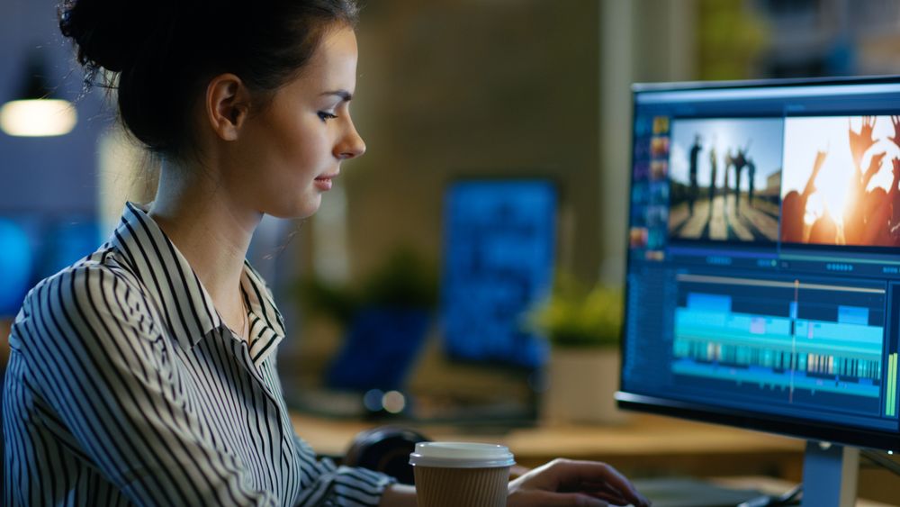 Female Videographer Edits Footage on Her Personal Computer, She Works in Creative Office Space Late