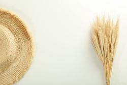 Top view of hat and bunch of dried flowers with copy space in between