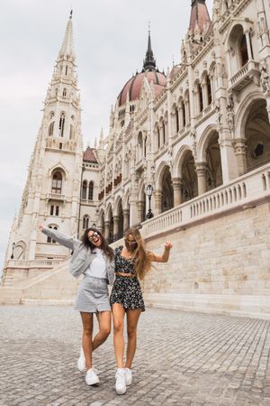 Funny girl friends on old square with dome buildings