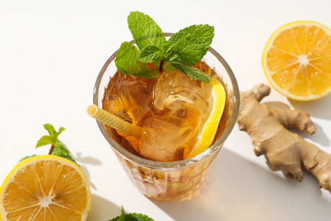 Cold tea with ice, orange slices and mint leaves and ginger