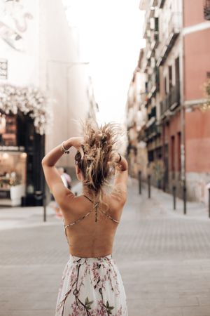 Slim woman in summer dress walking on city
