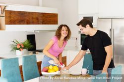 Happy adult couple standing near dining table and having fun 5oD319