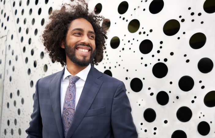 Cheerful entrepreneur standing next to wall