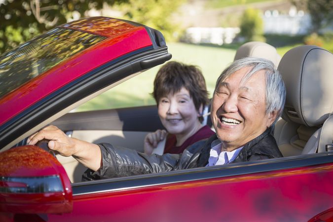 Happy Chinese Couple Enjoying An Afternoon Drive in Their Convertible
