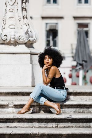 Black female siting on stairs outdoors