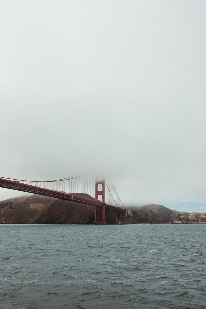 Red bridge construction over wavy dark water