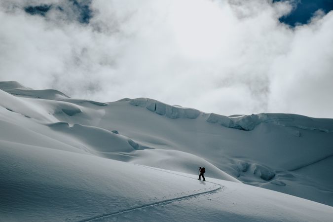 Person with backpack walking on snow covered ground