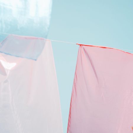 Pink and light hanging textile under blue sky in close-up