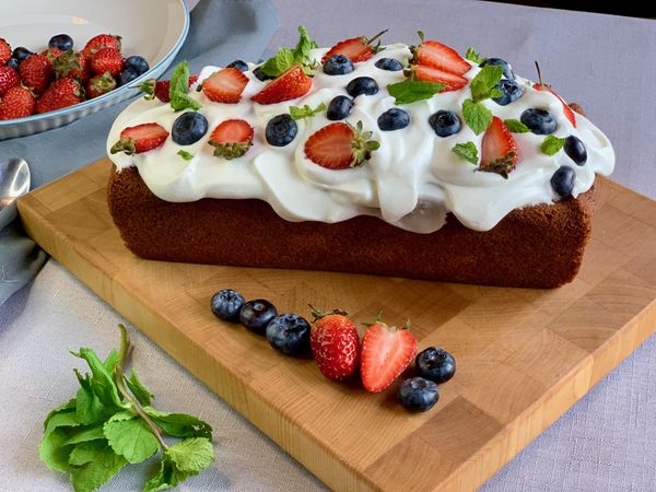Strawberry, blueberry, and mint cupcake topped with cream cheese frosting