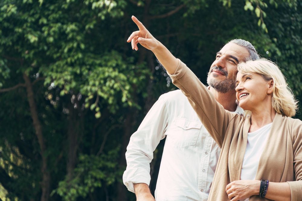 Woman pointing hand to sky and talking with a man