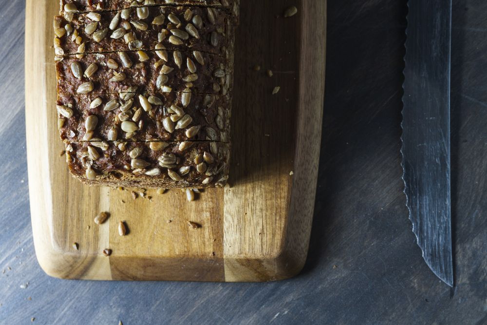 Sliced wholegrain bread on wooden cutting board