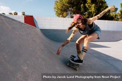 Skater female rides on skateboard at skate park ramp 4BONxb