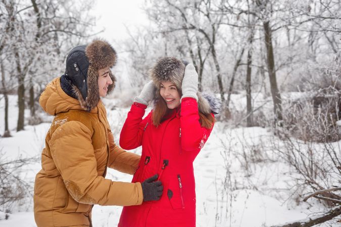 Laughing teenage boy and girl having fun in wintery forest