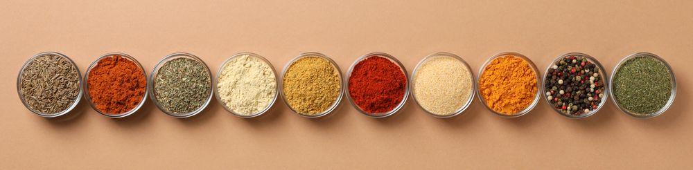 Banner of bowls of spices in row on beige table