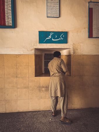 Back view of a man wearing kurta standing at a booth