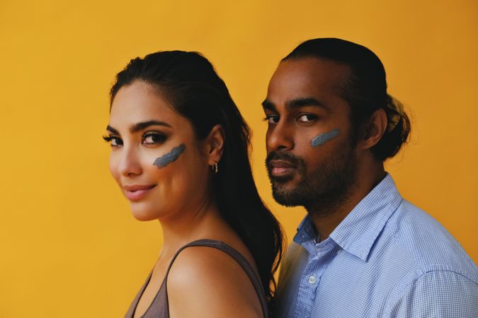 Man and woman smiling with skin care on cheeks