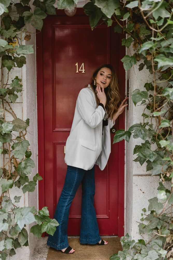 Stylish woman looking away near red door