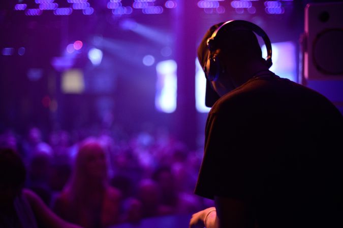 Man performing in silhouette against club lights