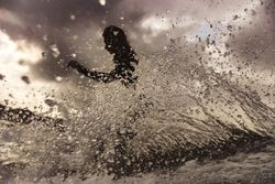 Woman on surf board floating on water between splashes