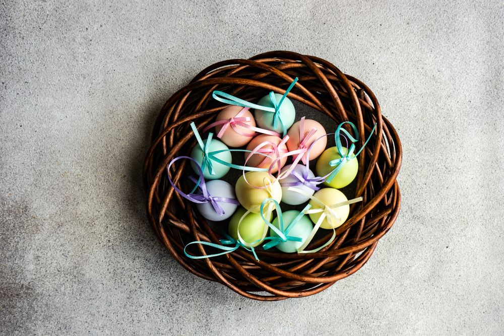 Easter card concept with line of pastel egg ornaments in neat nest