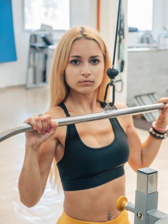 Fit woman doing lat pull-down exercise