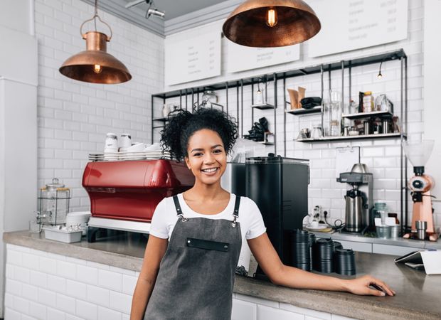 Proud cafe owner smiling at counter