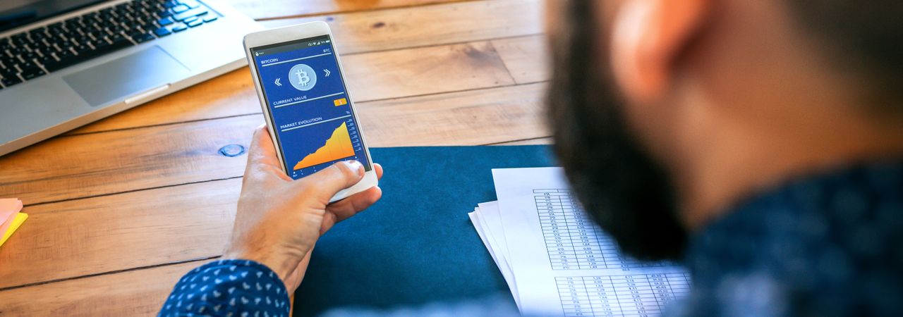 Businessman looking mobile with bitcoins information