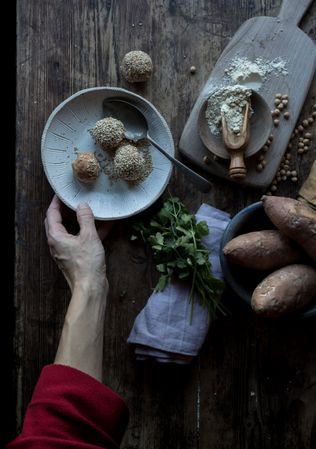 Person rolling in breadcrumbs sweet potatoes