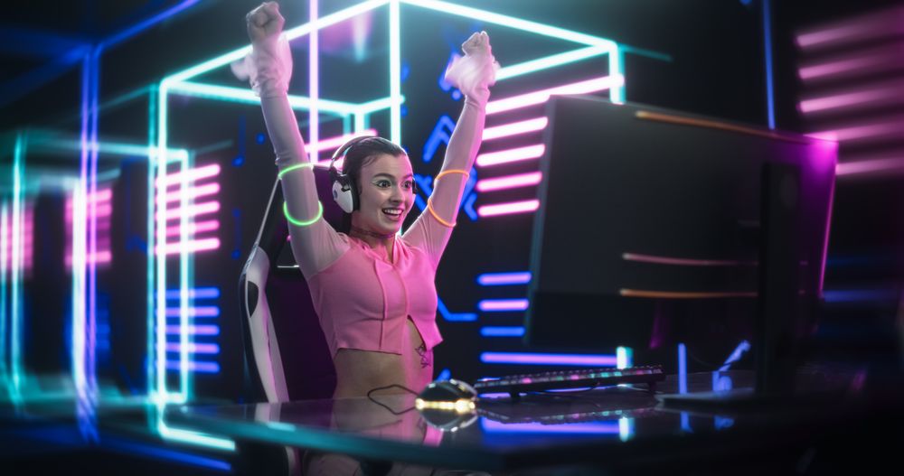 Internet Streamer  Desktop Computer in a Room with Futuristic Neon Background. Gamer Winning and Celebrating